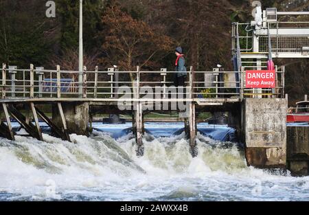 Ein Mitarbeiter der Umweltbehörde spaziert nach Storm Ciara, der das Land am Sonntag in die Stadt führte, über das Wehr bei Ray Mill Island, Maidenhead, Berkshire. Stockfoto