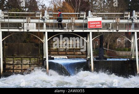 Ein Mitarbeiter der Umweltbehörde spaziert nach Storm Ciara, der das Land am Sonntag in die Stadt führte, über das Wehr bei Ray Mill Island, Maidenhead, Berkshire. Stockfoto