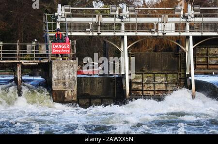 Ein Mitarbeiter der Umweltbehörde spaziert nach Storm Ciara, der das Land am Sonntag in die Stadt führte, über das Wehr bei Ray Mill Island, Maidenhead, Berkshire. Stockfoto