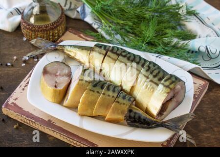 Mediterrane Küche, Fisch und Meeresfrüchte. Leckere, Appetitlich geräucherte Makrele mit Gewürzen auf dunklem rustikalem Holztisch. Stockfoto