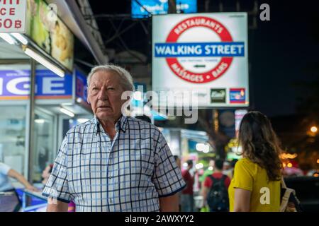 Thailand, Phuket, Patong, 1. Februar 2020 grau-haarige ältere europäische Touristen, die Bangla Road zu Fuß gehen. Verschwommener weicher Fokus Stockfoto