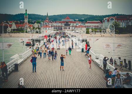 Touristen, die auf dem Holz-Sopot-Pier in der Danziger Bucht spazieren, sehen in Richtung Kurhaus Stockfoto