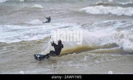 Worthing UK 10. Februar 2020 - Kite Surfer in Aktion vor Goring Beach in der Nähe von Worthing in West Sussex, da sie das Schlussende von Storm Ciara, der Großbritannien am Wochenende überboten hat, optimal nutzen: Credit Simon Dack / Alamy Live News Stockfoto