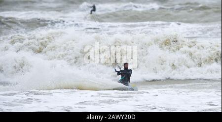 Worthing UK 10. Februar 2020 - Kite Surfer in Aktion vor Goring Beach in der Nähe von Worthing in West Sussex, da sie das Schlussende von Storm Ciara, der Großbritannien am Wochenende überboten hat, optimal nutzen: Credit Simon Dack / Alamy Live News Stockfoto