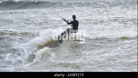 Worthing UK 10. Februar 2020 - Kite Surfer in Aktion vor Goring Beach in der Nähe von Worthing in West Sussex, da sie das Schlussende von Storm Ciara, der Großbritannien am Wochenende überboten hat, optimal nutzen: Credit Simon Dack / Alamy Live News Stockfoto