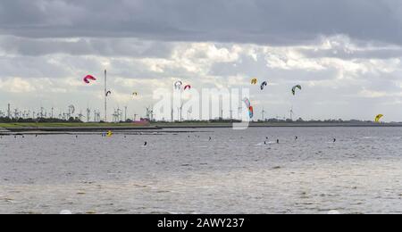 Stürmische Küstenlandschaft, darunter einige Kitesurfer bei Neuharlingersiel in Ostfriesland Stockfoto