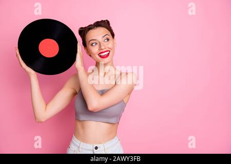 Portrait von netten Mädchen Musik Liebhaber halten Vinyl Platte Grammophone Disc wollen Retro Party tragen Freizeit Kleidung isoliert über rosa Farbe Stockfoto