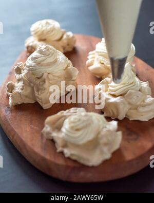 Der Prozess, Pavlova Dessert zu kreieren und das Meringue mit Sahne zu schmücken Stockfoto