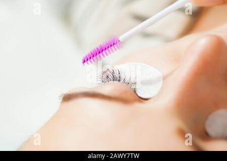 Professioneller Kosmetologe, der das Makro für das Verfahren zur Laschenverlängerung verwendet Stockfoto