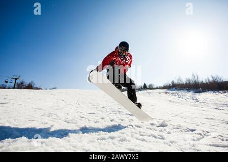 Männliche Snowboarder im Einsatz springen über Hügel Stockfoto