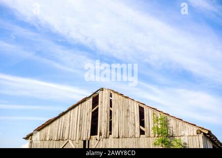 Dach eines alten kaputten Scheune, blauer Himmel mit Wolken Stockfoto