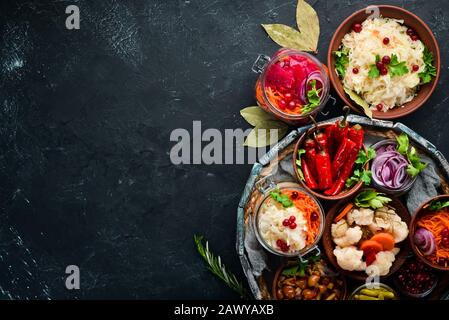 Gefülltes Gemüse und Pilze auf dem Küchentisch. Kohl, Pilze, Gurken, Blumenkohl. Draufsicht. Freier Speicherplatz für Ihren Text. Stockfoto