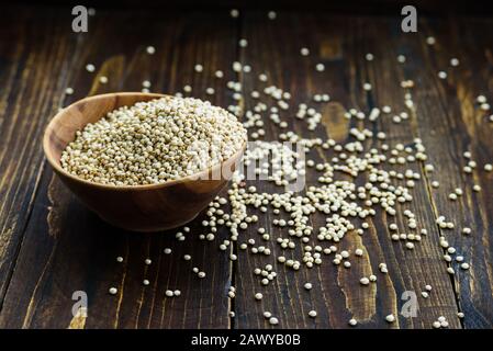 Holzschale mit Sorghumkorn auf dunklem Holztisch Stockfoto