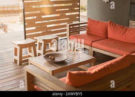 Rosengwein und Sofa auf Holz, moderne, luxuriöse Haus-Vorzeigeterrasse Stockfoto