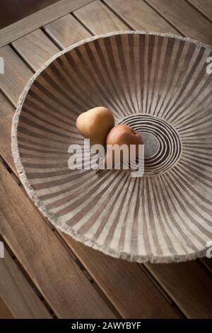 Stillleben Birnen in Keramikschale mit Muster auf Holztisch Stockfoto