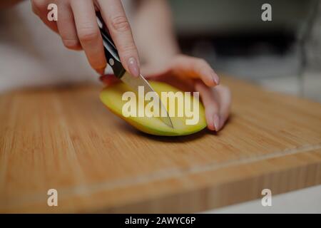 Frau Schneidet Mango-Früchte mit Scharfem Messer Stockfoto