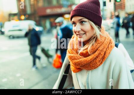 Junge Frau in Strumpfkappe und Schal auf der städtischen Straße Stockfoto
