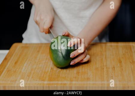 Frau Schneidet Mango-Früchte mit Scharfem Messer Stockfoto