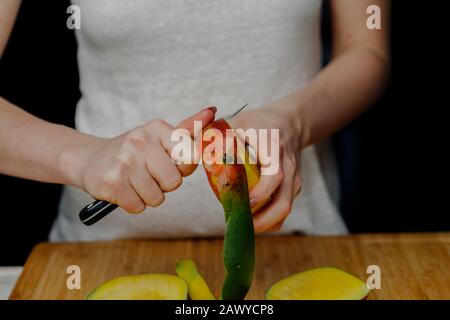 Frau Schneidet Mango-Früchte mit Scharfem Messer Stockfoto