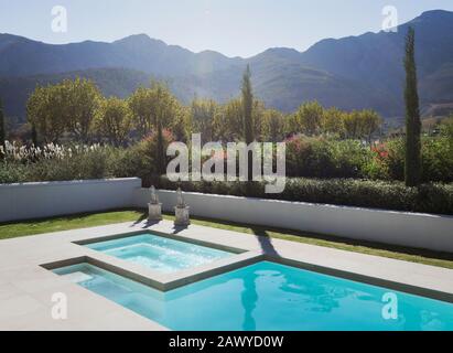 Sonniger, idyllischer Pool mit Whirlpool und ruhigem Blick auf die Berge Stockfoto