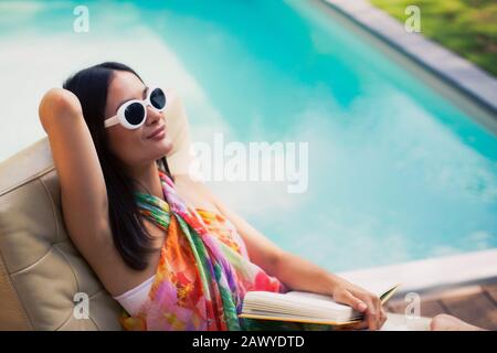 Ruhige Frau, entspannend, Lesebuch im Sommer am Pool Stockfoto