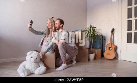 Das junge Ehepaar ruft Freunde oder Verwandte per Video an, zieht in eine neue Wohnung oder Stadt Stockfoto