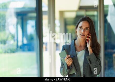 Geschäftsfrau, reden über Handy im Korridor Stockfoto