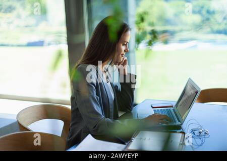 Geschäftsfrau, die von zu Hause aus am Laptop arbeitet Stockfoto