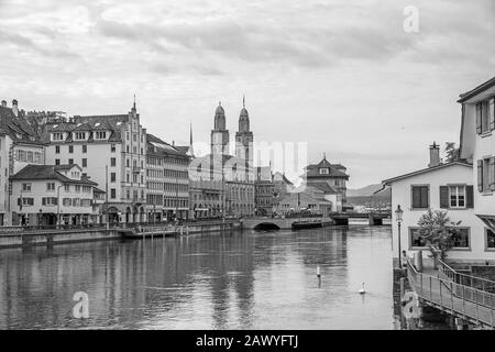 Blick auf die Innenstadt von Zürich von Brücke Rudolf-Brun-Brucke, Großmunster, Rathaus und Limmat vorne - schwarz-weiß. Stockfoto