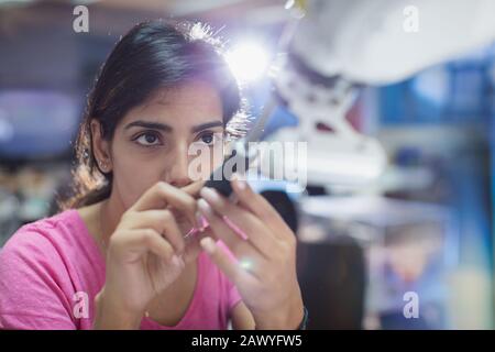 Fokussierter Inneningenieur mit Schraubendreher zur Befestigung des Roboterarms Stockfoto
