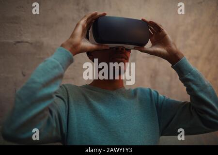 Portrait von afroamerikanischem Mann mit VR-Ausrüstung und beeindruckendem Erlebnis, Platz für Kopien Stockfoto