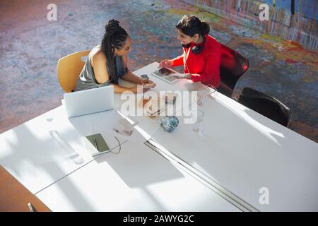 Kreative Geschäftsfrauen, die mit einem digitalen Tablet sprechen und in Konferenzräumen planen Stockfoto