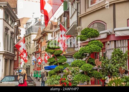 Straße Augustinergasse in Zuerich, Stadtteil Lindenhof mit schweizer Flaggen. Stockfoto