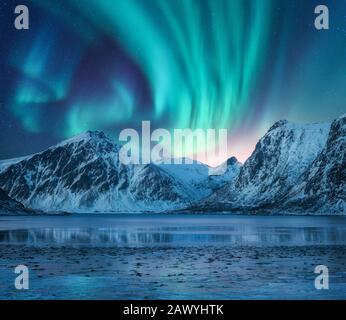 Nordlichter über schneebedeckten Felsen. Winterlandschaft Stockfoto