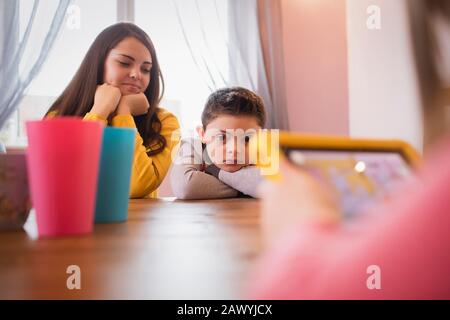 Junge mit Down-Syndrom am Esstisch mit Schwester Stockfoto