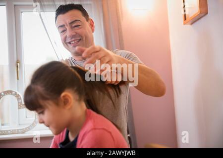 Junge putzen Haare der Tochter im Badezimmer Stockfoto
