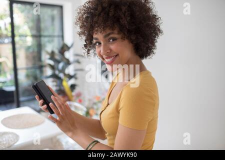 Portrait fröhliche junge Frau mit Smartphone Stockfoto
