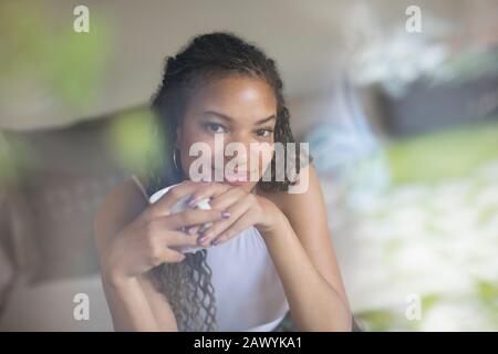 Portrait lächelnde, selbstbewusste junge Frau, die Kaffee trinkt Stockfoto