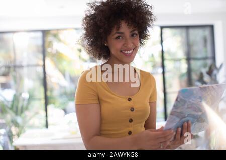 Portrait selbstbewusste lächelnde junge Frau mit Laptop Stockfoto