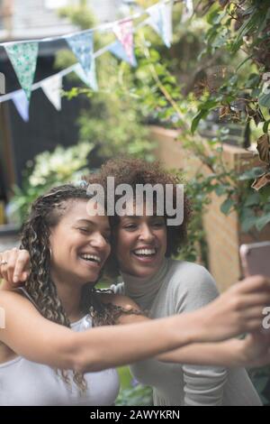 Fröhliche unbeschwerte junge Frauen Freunde, die selfie mit dem Kameratelefon nehmen Stockfoto