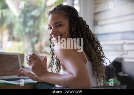 Portrait fröhliche junge Freiberuflerin, die am Laptop arbeitet Stockfoto