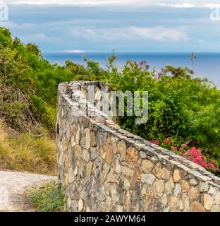 Alte Steinwand mit entferntem Ozean in St. Martin Stockfoto