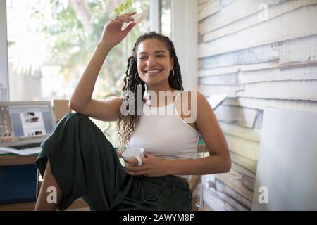 Portrait fröhliche, unbeschwerte junge Frau im Heimbüro Stockfoto