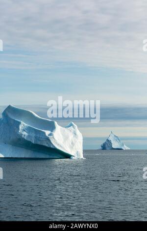 Majestätische Eisberg-Formationen auf dem sonnigen Atlantischen Ozean Grönlands Stockfoto