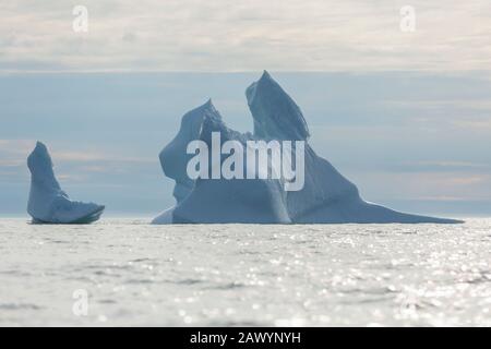 Majestätische Eisberg-Formationen auf dem sonnigen Atlantischen Ozean Grönlands Stockfoto