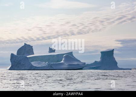 Majestätische Eisberg-Formationen über dem sonnigen Atlantischen Ozean Grönlands Stockfoto