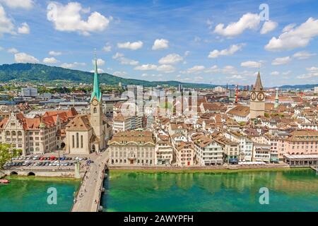 Züricher Innenstadt mit berühmter Fraumunster Kirche, Peterskirche und Limmat - Blick von der Großmunster Kirche an einem sonnigen Tag mit Wolken in Summe Stockfoto