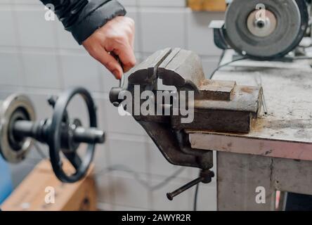Der Mechaniker verwendet den Schraubstock in der Garage Stockfoto