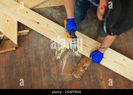 Tischlerei, die Holz mit Säge auf der Baustelle schneidet Stockfoto