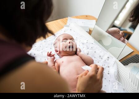 Mutter wechselt Windel des neugeborenen Kindersohns Stockfoto